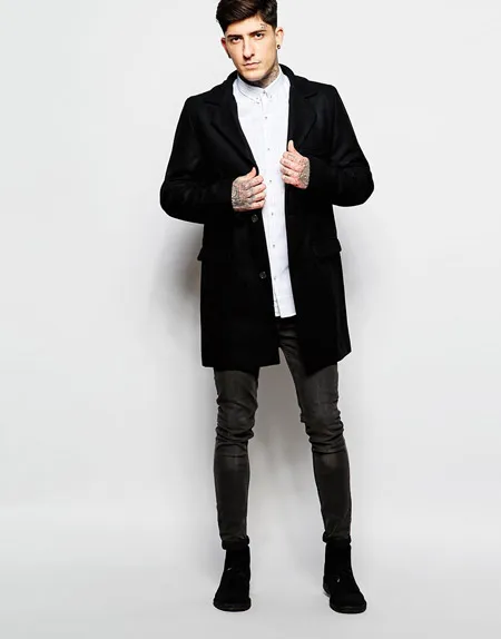 Мужчина в черном пальто и узких брюках.