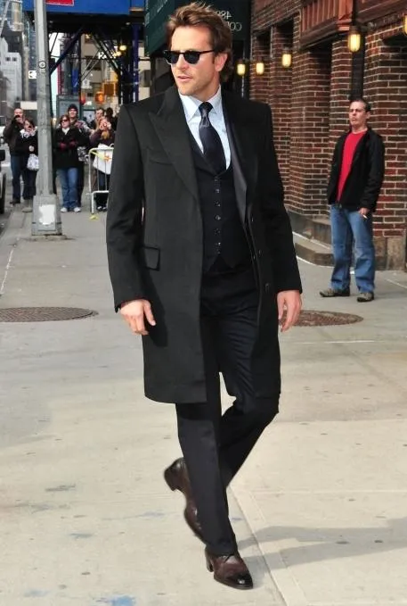 Брэдли Купер в черном пальто.