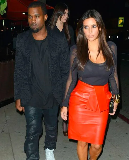 Ким Кардашьян в черной блузке и красной юбке с Канье Уэстом