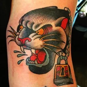Татуировка на руке мужчины - пантера с цепью и висячим замком