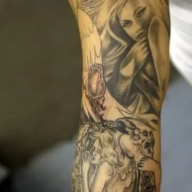 Татуировка на руке мужчины - ангел и демоны