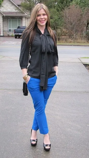 Молодая девушка в синих брюках и черной блузке