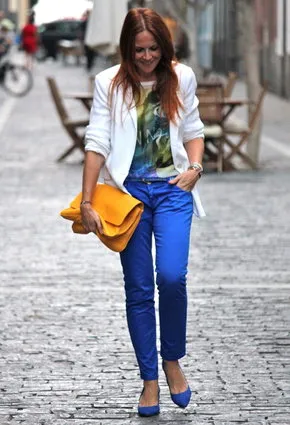 Молодая девушка в синих брюках и цветной блузке