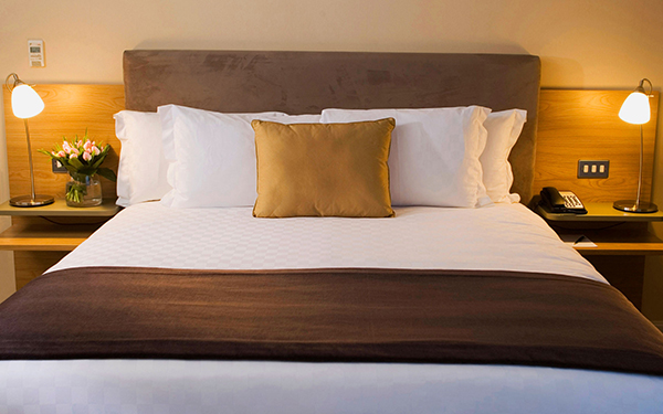 Двуспальная кровать с белым постельным бельем